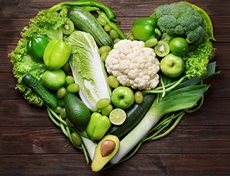 Grünes Obst und Gemüse in Herzform gelegt